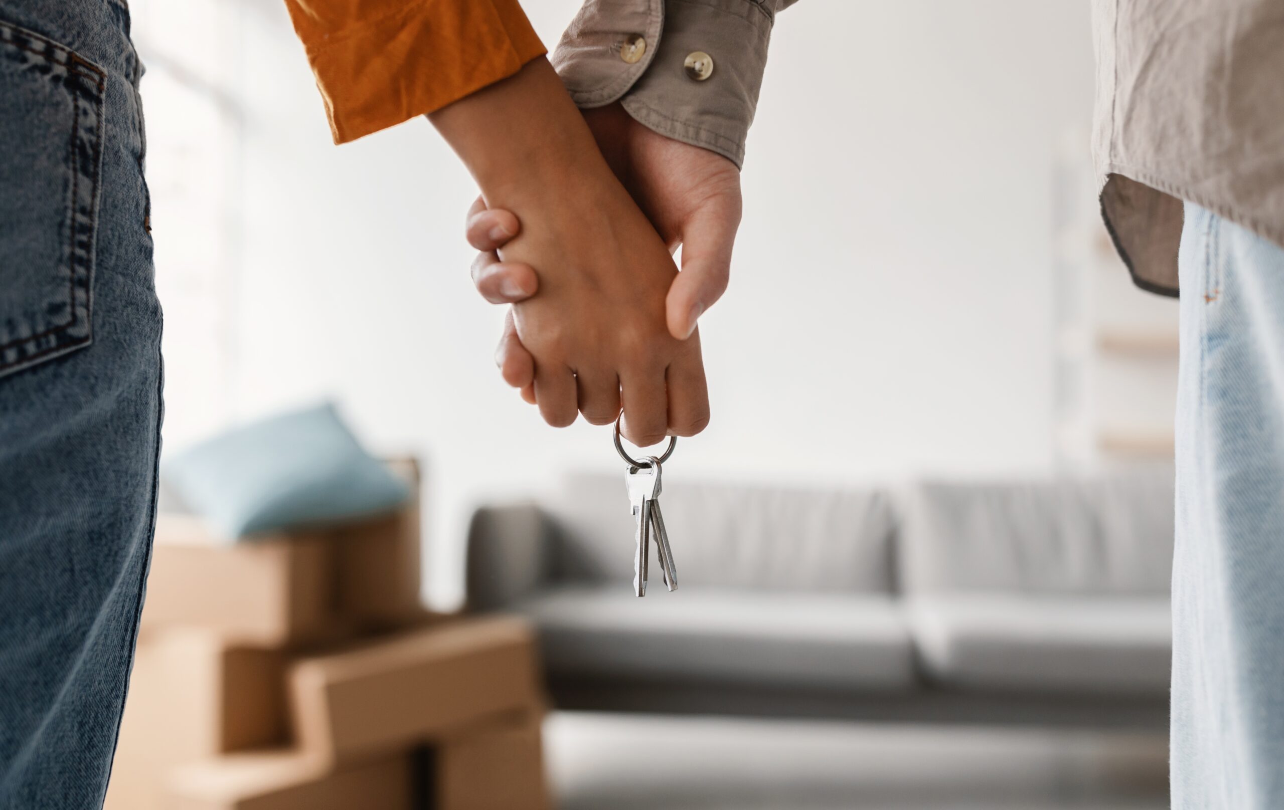 Closeup,Of,Young,Couple,Holding,Hands,And,New,House,Key,