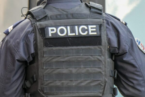 Policier de dos portant un gilet, illustrant la sécurité estivale