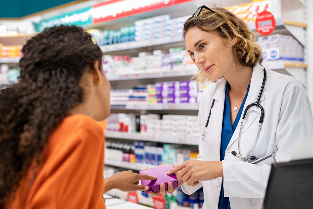 Un pharmacien remet une boîte, illustrant le remboursement des médicaments