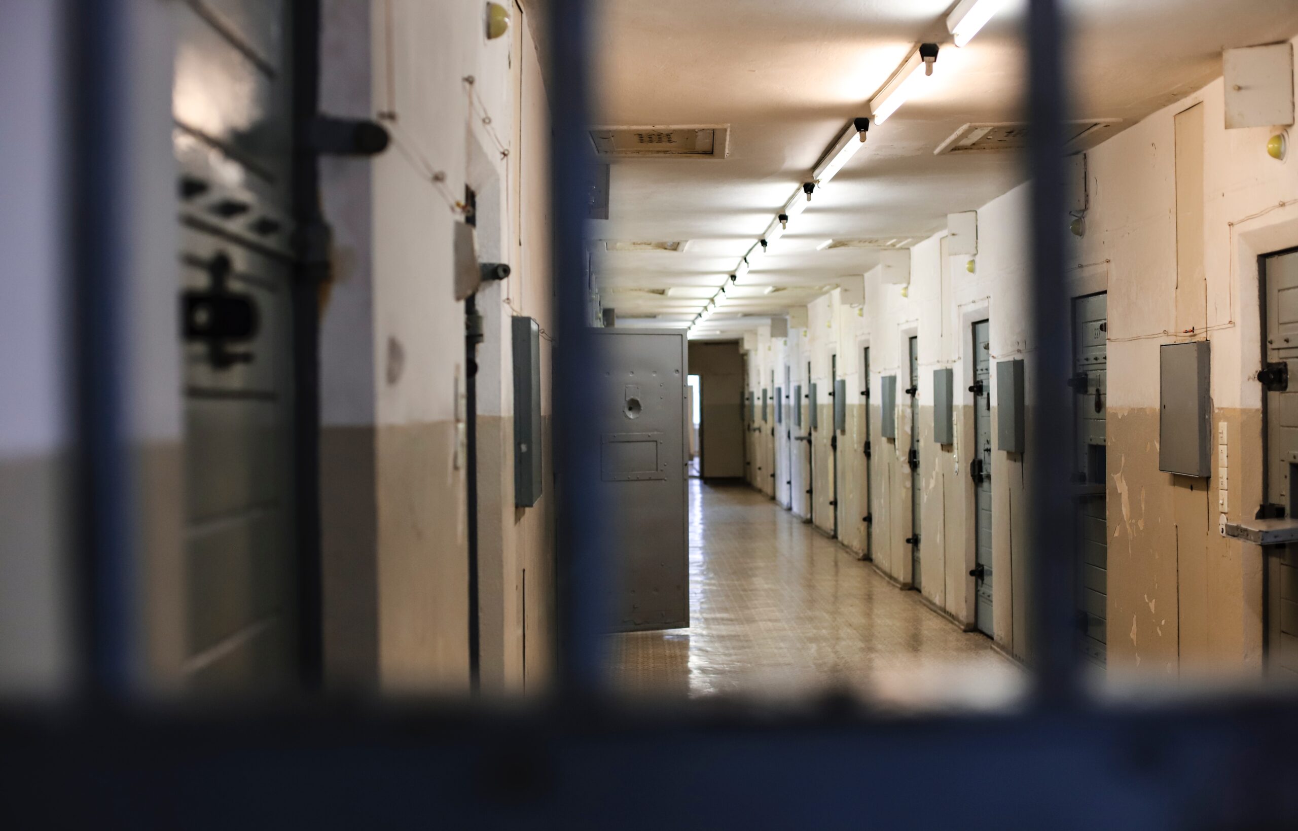 Couloir de cellules derrière des barreaux, symbole des suicides en prison