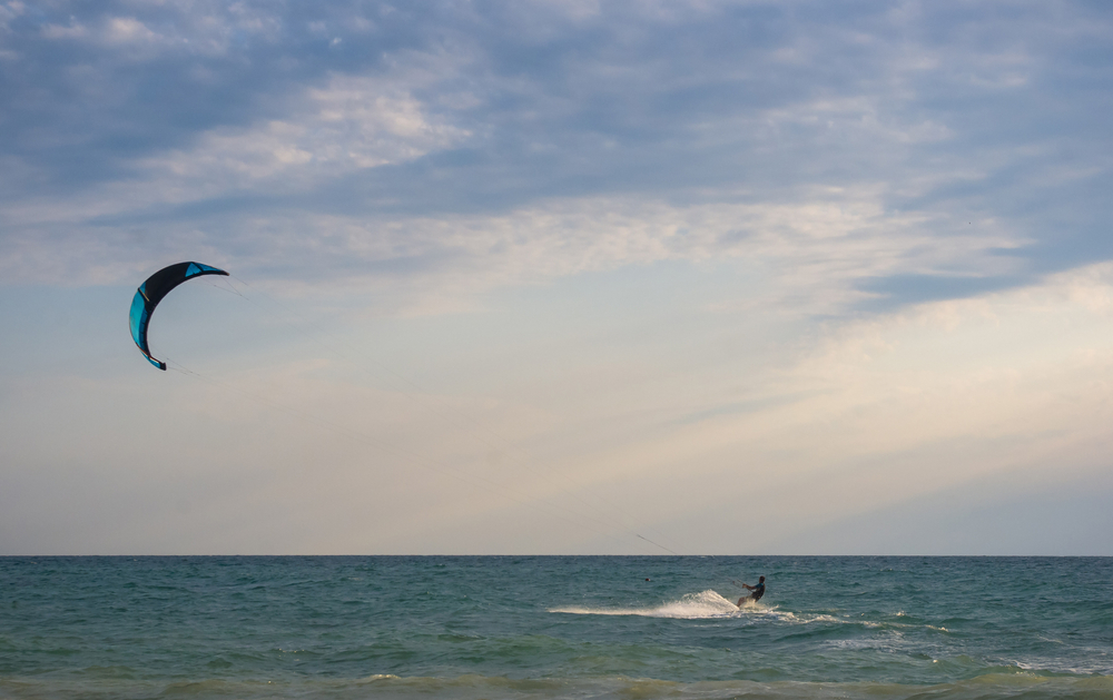 Kitesurfer,Rides,A,Kite-surf,On,Waves,Of,The,Sea,In Kitesurfeuse évoluant en pleine mer, à l’image de Lauriane Nolot