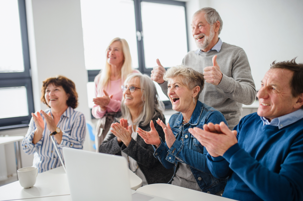 groupe de seniors applaudissant lors d'une activité de la Semaine Bleue