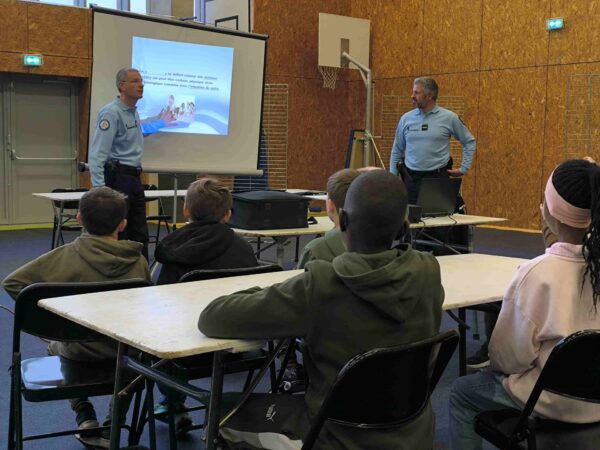Gendarmes sensibilisant des collégiens dans une salle