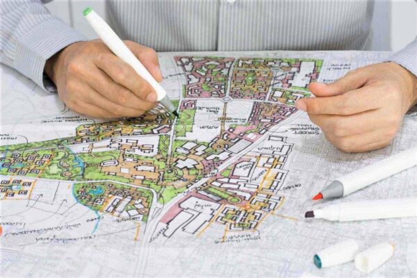 Mains dessinant un plan d'urbanisme pour l'enquête publique