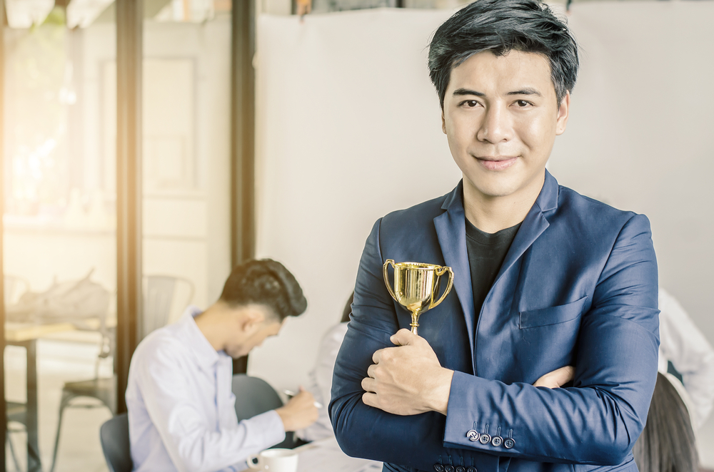 Homme d'affaires tenant un trophée remis par la métropole